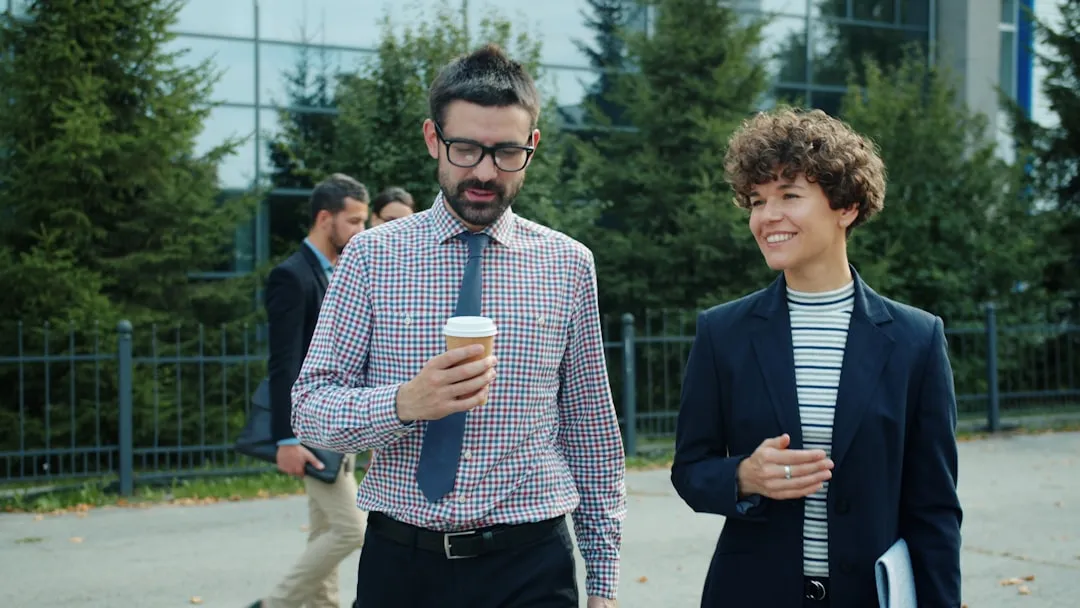 Two colleagues walking and talking outside office building