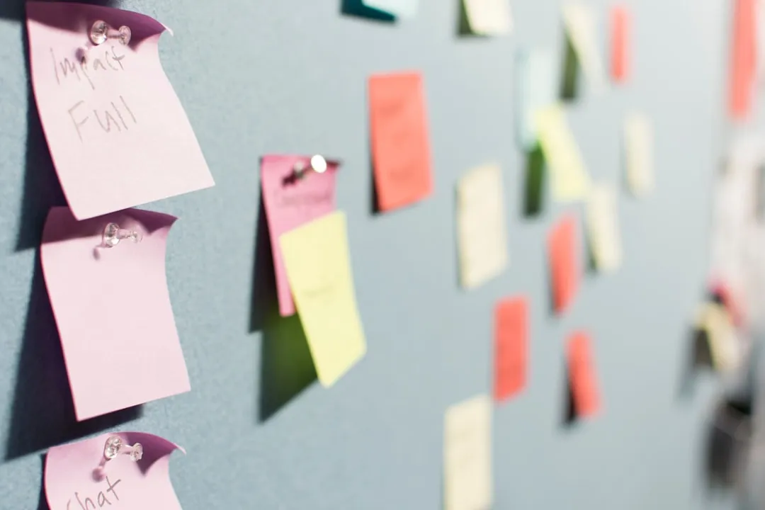 Pink, yellow, and orange sticky notes pinned to a wall, one labeled "Impactful"
